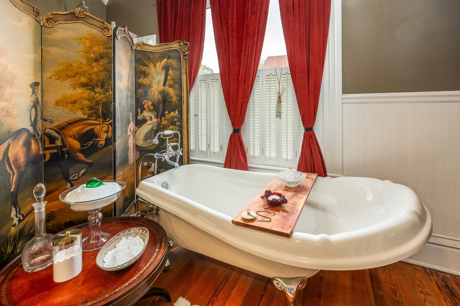 Bathroom with full bathtub and red curtains. 